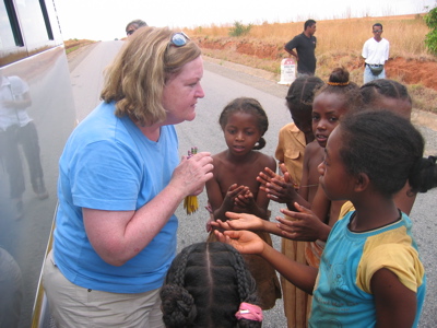 Allison handing out pencils to the children.